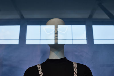 Rear view of man standing against window