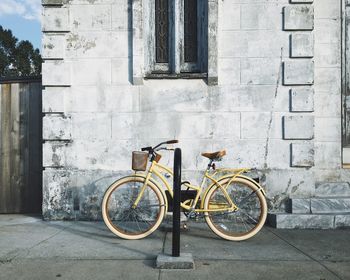 Bicycle parked on footpath by building