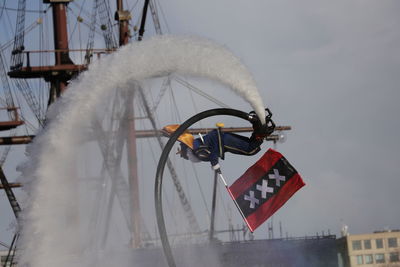 Man flyboarding water sport against sky