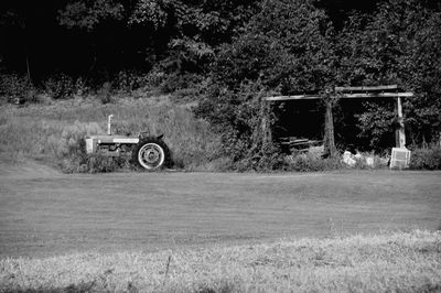 Tractor on field against trees