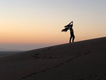 Full length of silhouette man at beach against sky during sunset