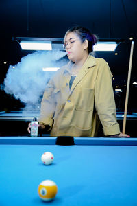 Portrait of woman playing pool