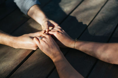 Cropped image of couple holding hands at table