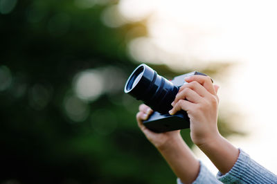 Cropped hand holding camera