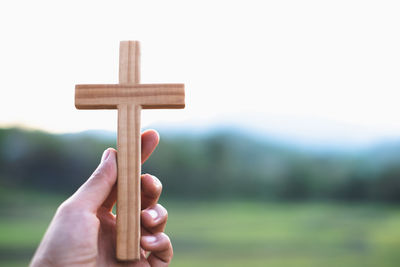 Cropped hand of person holding wooden post