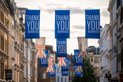 Low angle view of text amidst buildings in city