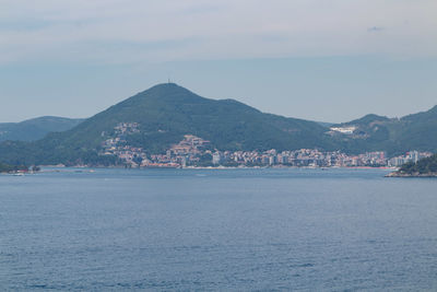 Scenic view of sea by buildings against sky