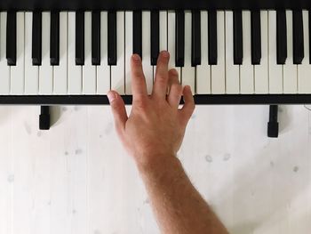 Cropped image of hand playing piano