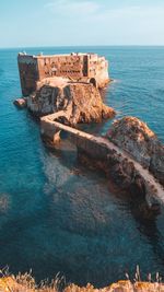 Scenic view of rock formation in sea against sky