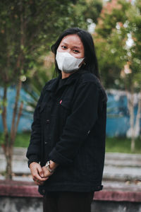 Portrait of teenage girl wearing mask outdoors