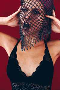 Midsection of woman wearing mask against gray background