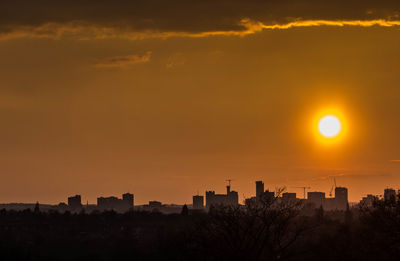 Silhouette buildings against sky during sunset