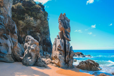 Rock formations in sea against blue sky