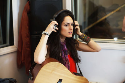 Young woman playing acoustic guitar at a recording studio