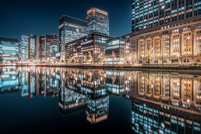 Reflection of illuminated buildings in lake at night