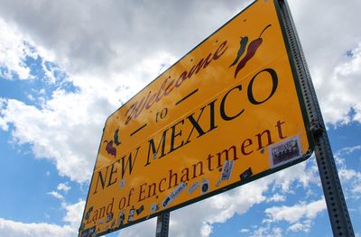 Low angle view of information sign against sky