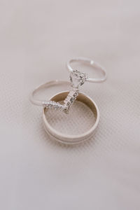 Close-up of wedding rings on table against white background