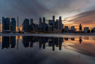 Reflection of buildings in city at sunset