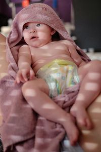 Close-up of cute baby girl in towel
