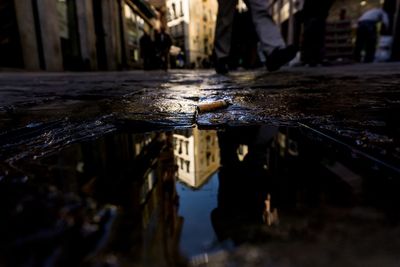 Reflection of buildings in puddle on street