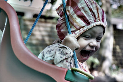 Close-up of baby enjoying on swing