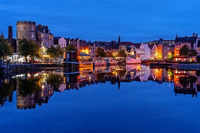 Reflection of illuminated buildings in water at dusk