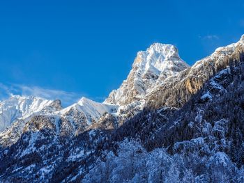Scenic view of snowcapped mountains against blue sky
