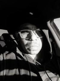 Portrait of man wearing sunglasses sitting in car