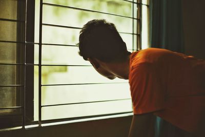 Close-up of man standing on window