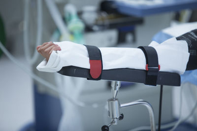 Cropped hand of patient hand on hospital bed