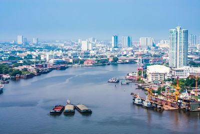 Boats in river with city in background
