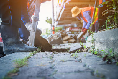 Low section of man standing on wood by building