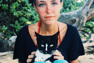 Portrait of young woman with cat