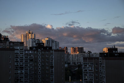 Buildings in city against sky at sunset