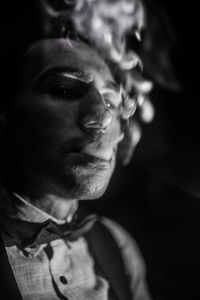 Close-up of man looking away while smoking