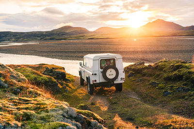 4x4 truck looks out over sunrise landscape in iceland