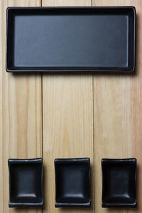 Empty rustic black plate over wooden table. aerial view, with copy space.