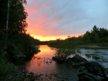 Scenic view of river against sky at sunset