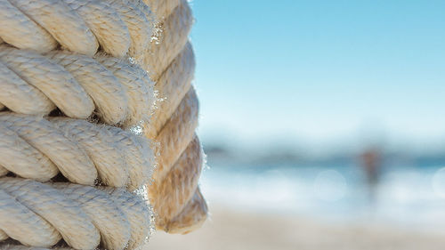 Close-up of rope tied to sea against sky