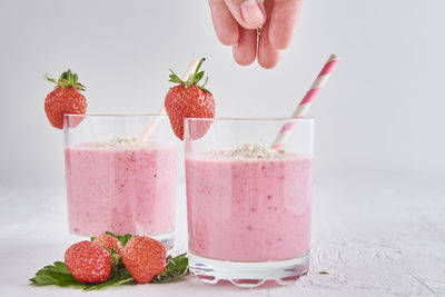 Strawberries in glass jar against white background