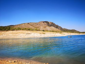 Scenic view of sea against clear blue sky