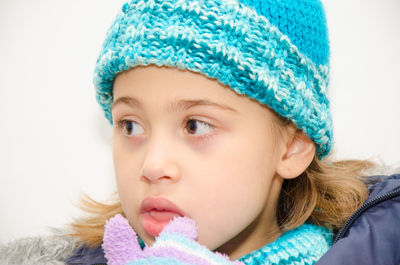 Close-up of cute girl in warm clothes against white background