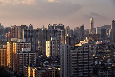 Aerial view of buildings in city against sky during sunset