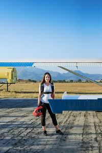 Young female skydiver with backpack in an airfield