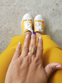 Low section of woman wearing ring on footpath