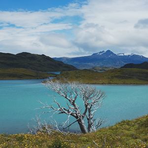 Scenic view of lake by mountains against sky