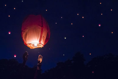 Low angle view of illuminated lantern against sky at night