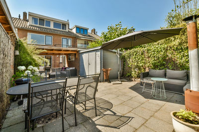 Empty chairs and tables in front of house