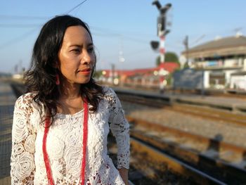 Woman standing at railroad station while looking away