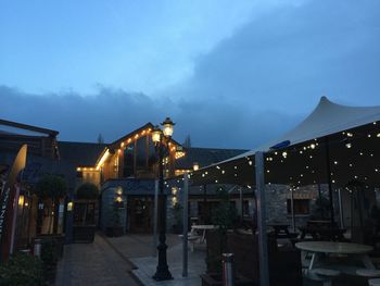 Illuminated built structure against sky at dusk